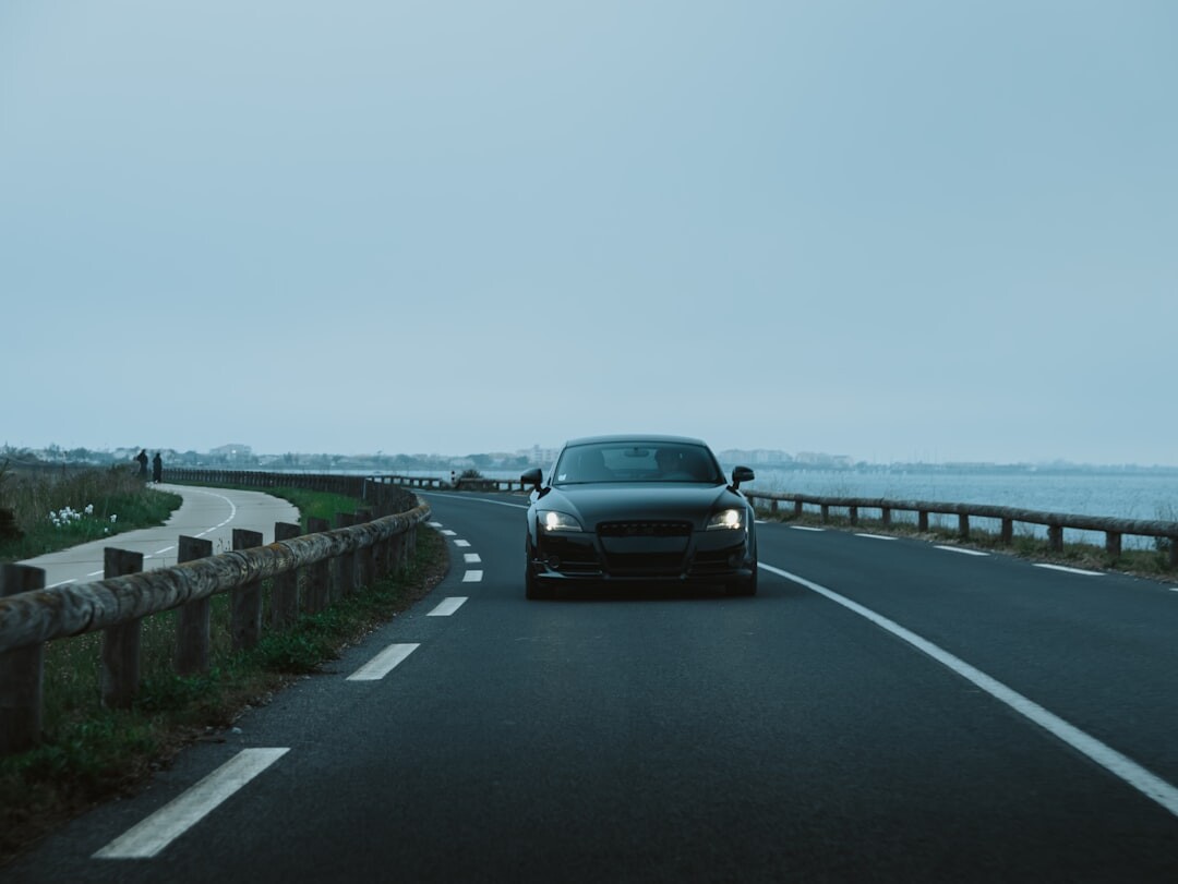 Vintage sports car driving along a coastal road in Punta del Este at sunset