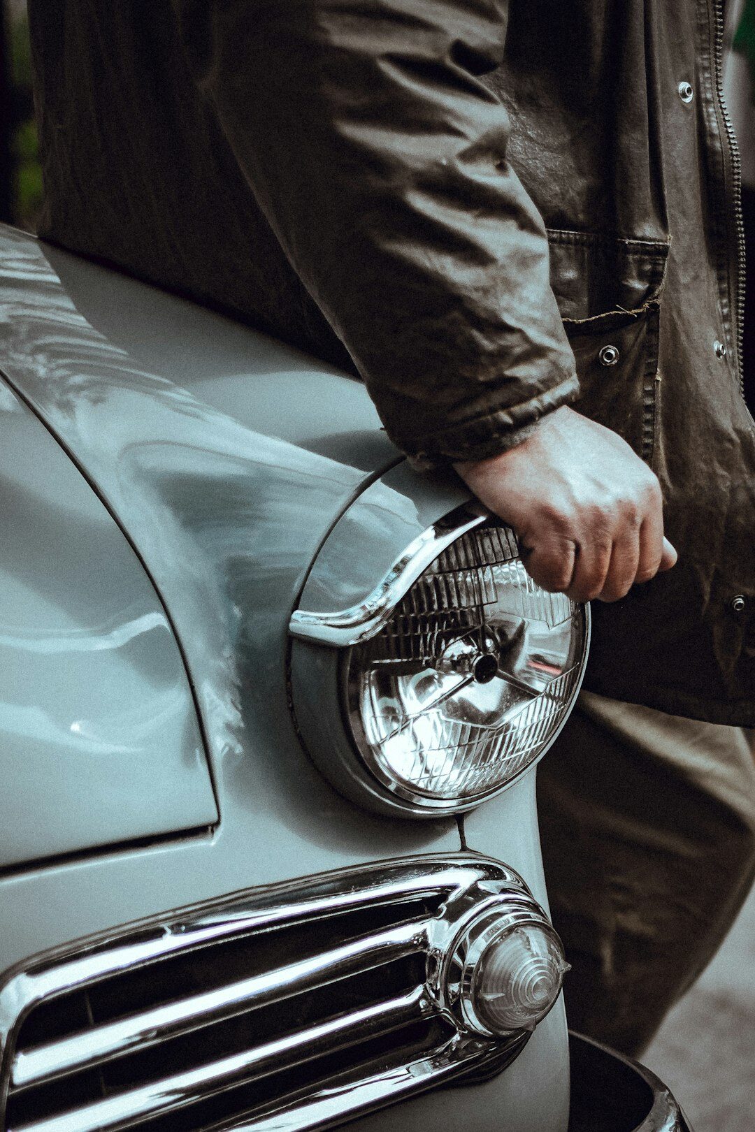 Portrait of an Uruguayan man in his sixties standing in his private car collection