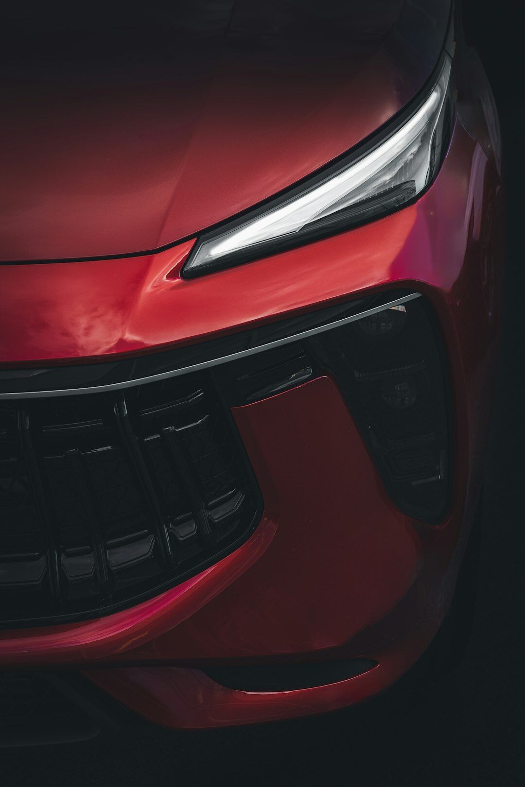 Dramatic studio photograph of a modern hypercar with sharp lighting